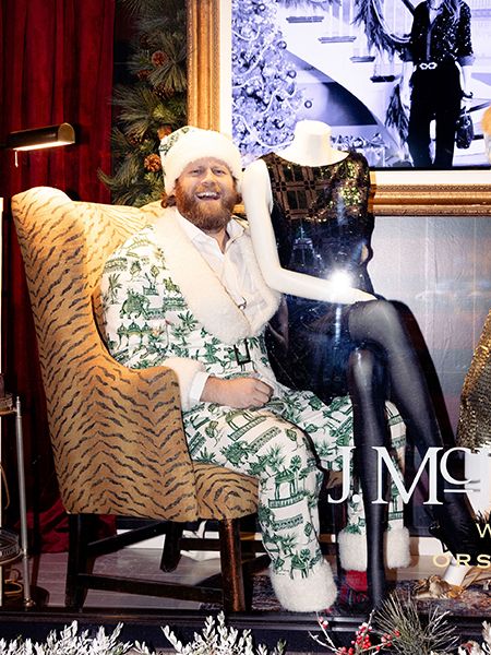 Man in a santa hat posed in a festive holiday inspired outfit