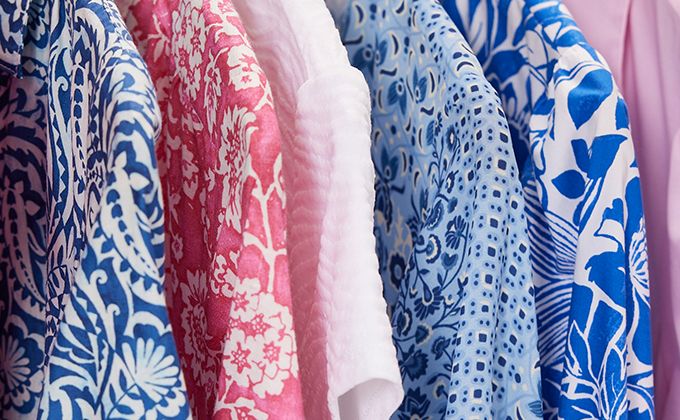 A variety of prints and fabrics hanging on a rack