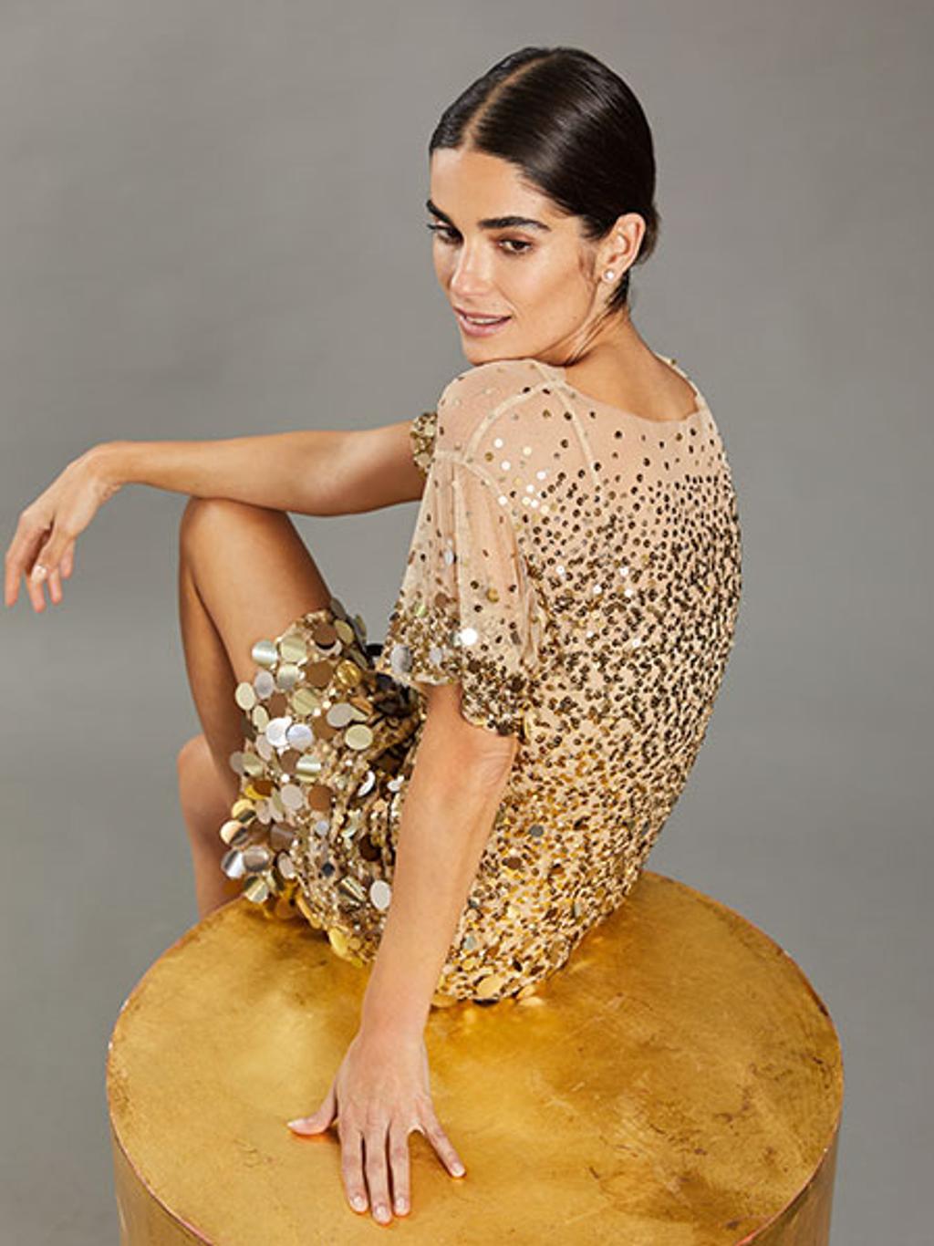 Model wearing gold sequined dress