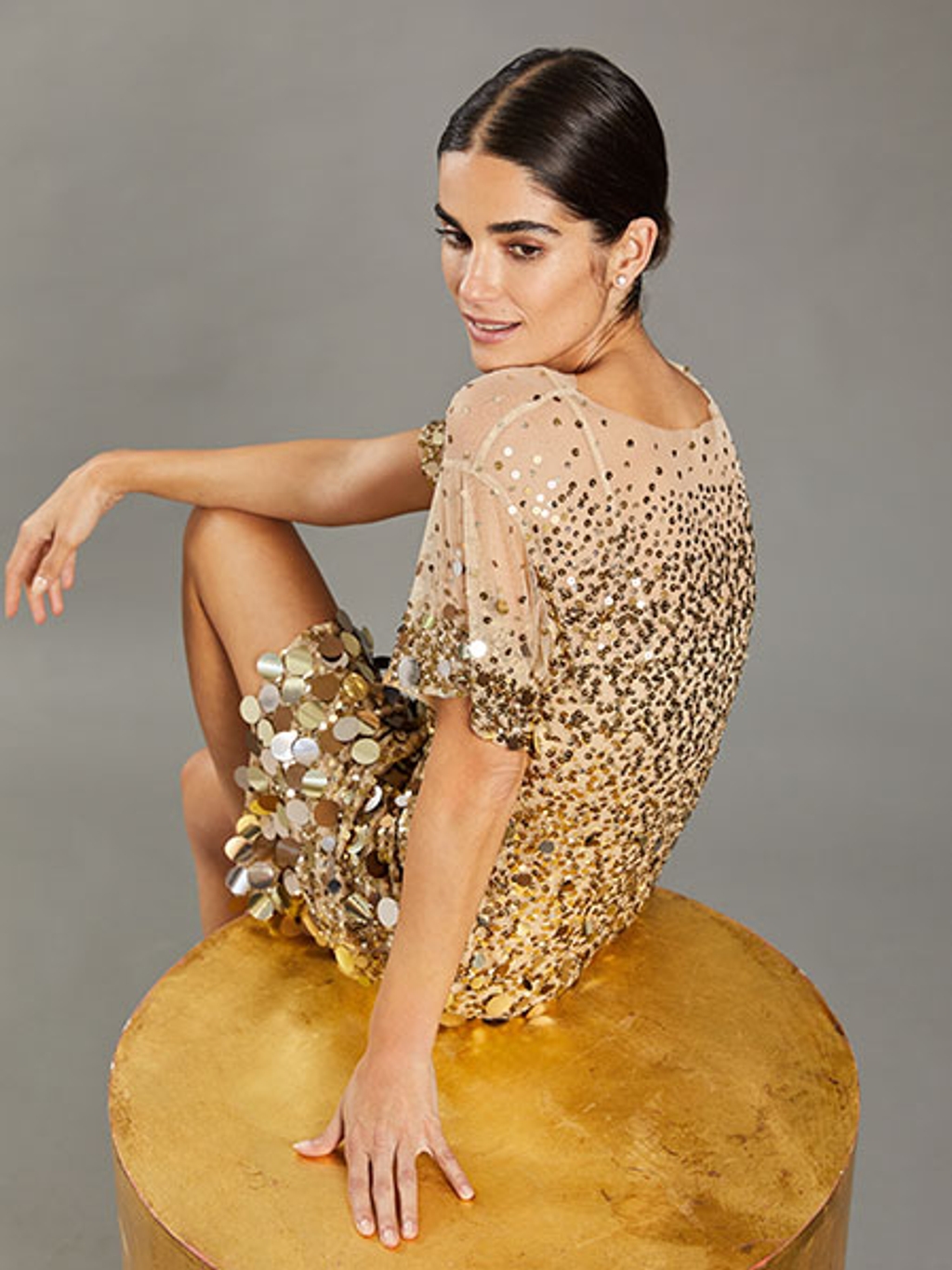 Model wearing gold sequined dress Model wearing gold sequined dress