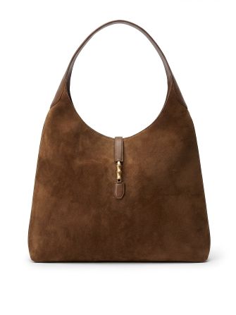 still life of women's brown suede hobo bag against white seamless background
