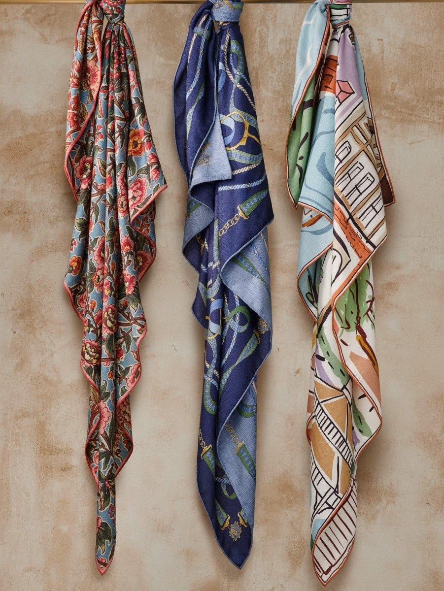 womens silk printed scarves hanging on a bar in various patterns