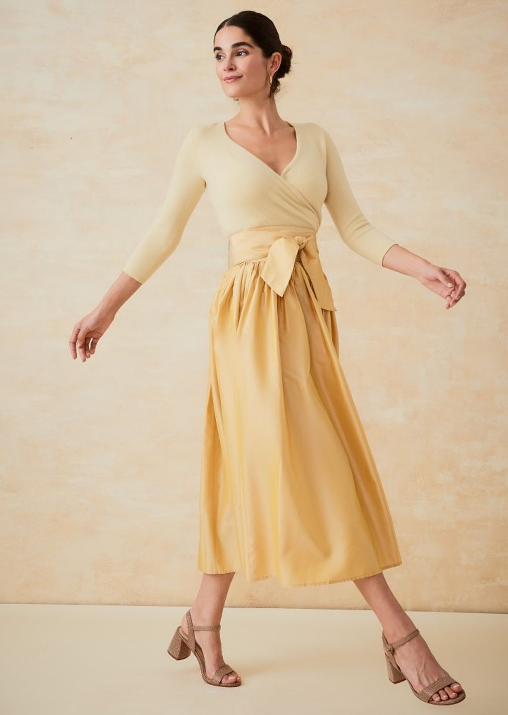 woman in yellow wrap sweater and gold taffeta ball skirt