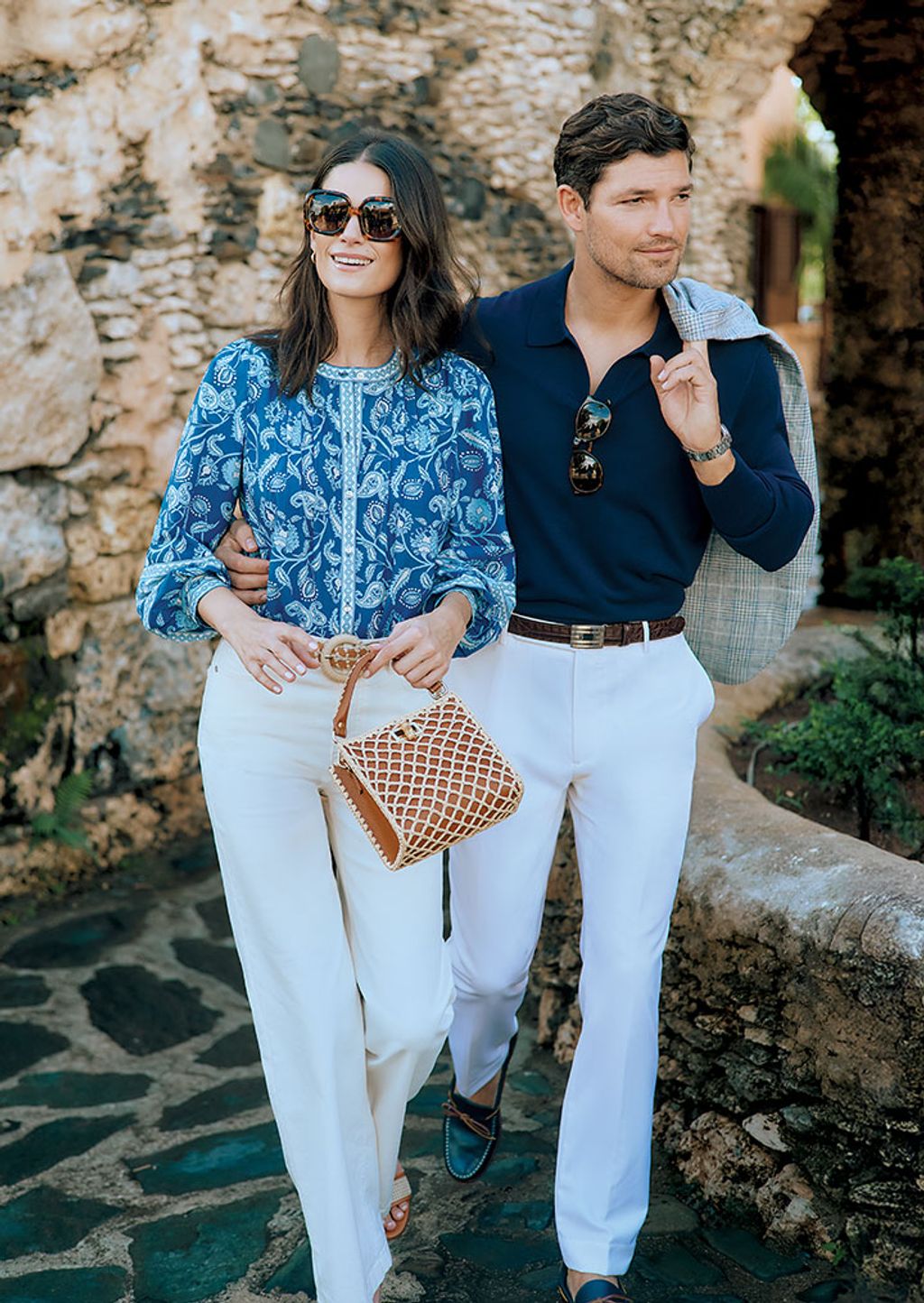 Woman seated on a chair wearing a matching shirt and pant in a white and blue chinoiserie print.