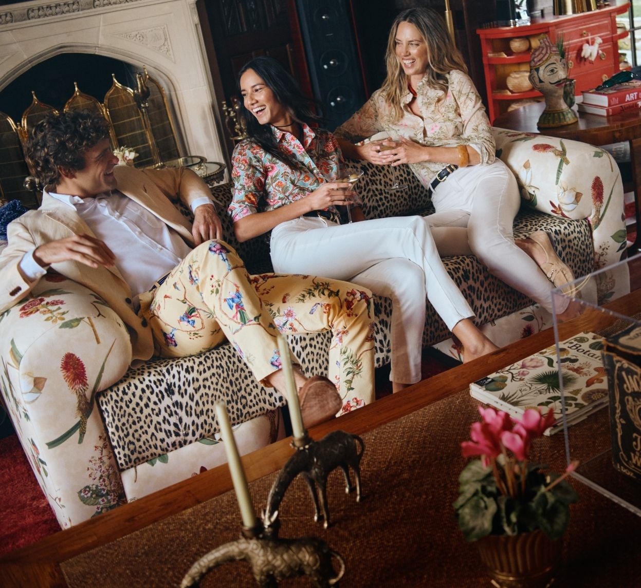 group sitting inside, women wearing printed button down shirts and white jeans