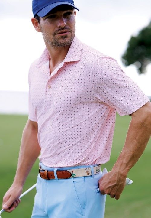 man on golf course wearing pink polo shirt