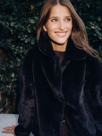 close up image of woman wearing faux fur jacket outside