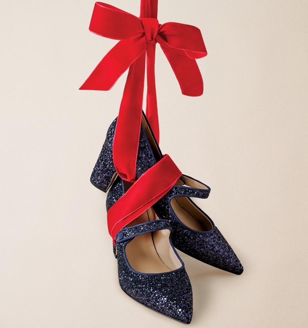 Navy blue glitter Mary Jane heels suspended by a red velvet ribbon and bow.