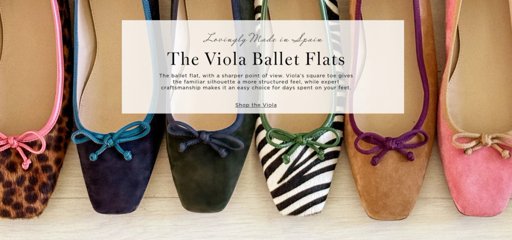 A row of seven Viola Ballet Flats in various colors and patterns, including leopard and zebra print, with square toes and bows. Lovingly Made in Spain.