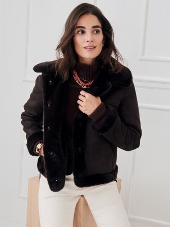 woman wearing brown shearling and suede reversible jacket with brown turtleneck sweater