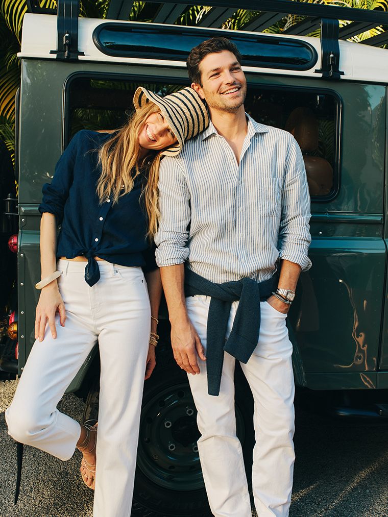 woman standing outside wearing navy linen button down with white jeans standing next to man in striped linen shirt and white jeans. 