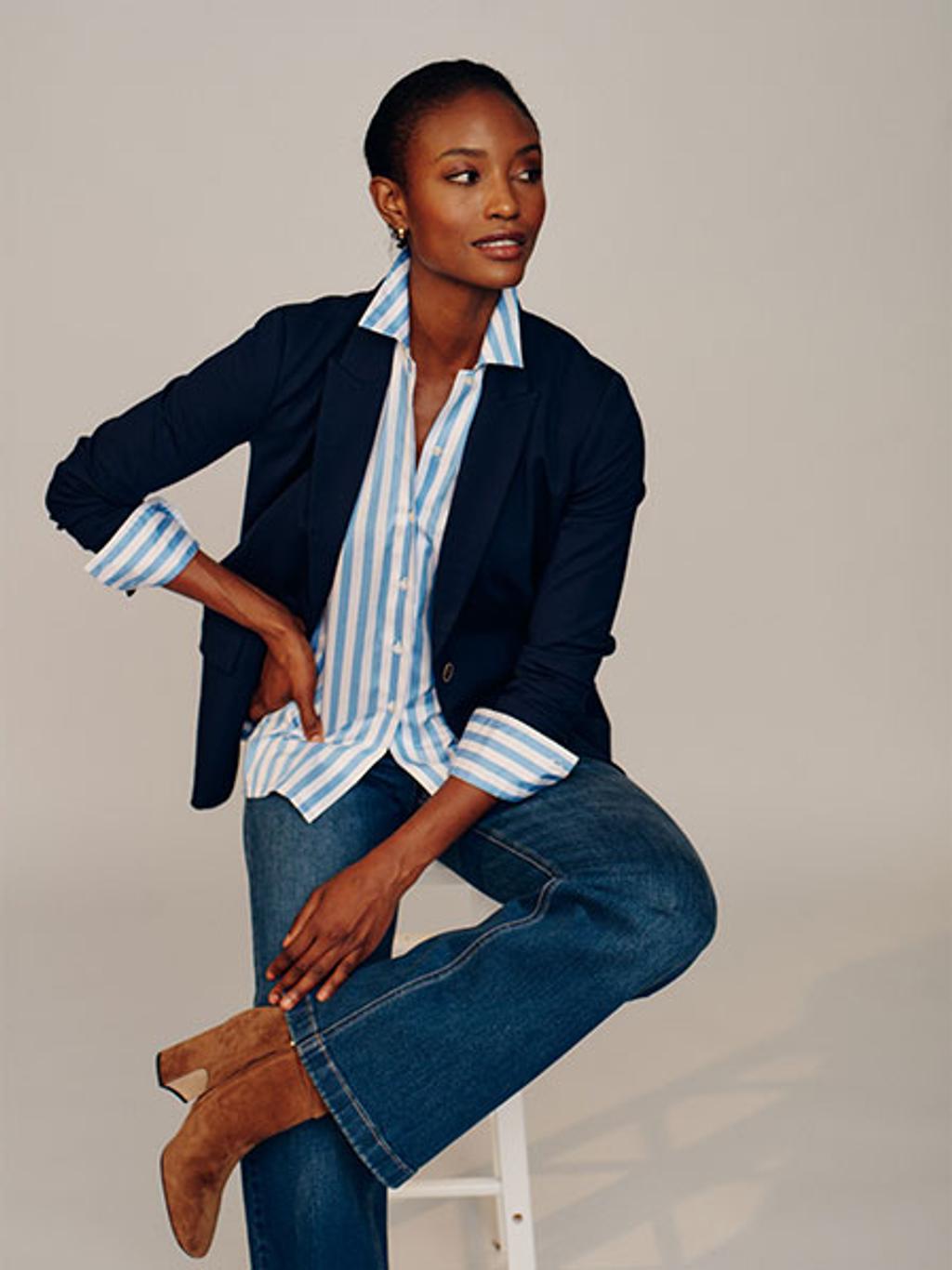 Model in blazer, striped button-down, jeans, and boots