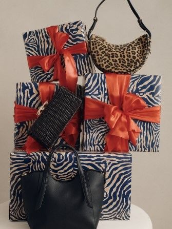 stack of wrapped presents with ladies handbags positioned around