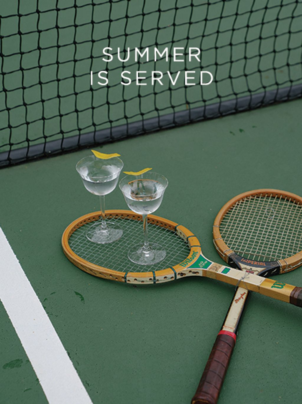 Martinis balanced on tennis racket on a tennis court