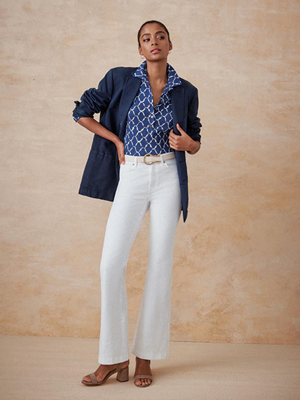 Model wearing white jeans, polo, and blazer