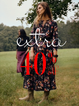 woman standing outside on lawn in black floral printed long dress