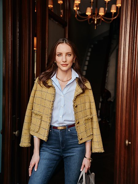 Model in yellow jacket, striped shirt, and blue jeans
