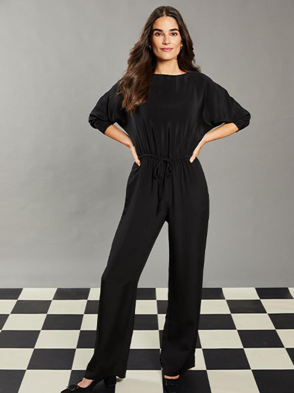Model wearing black silk jumpsuit