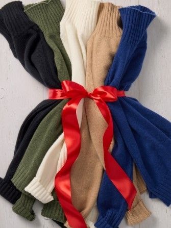 laydown of womens cashmere turtlenecks tied with red bow