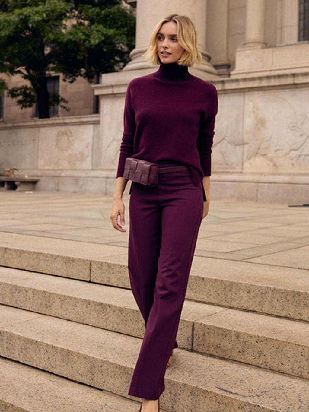 Woman in burgundy sweater and pants on museum steps Woman in burgundy sweater and pants on museum steps