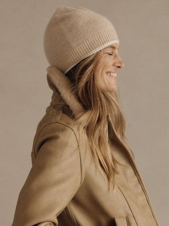 cropped in profile of woman wearing beige and cream cashmere fitted knit hat