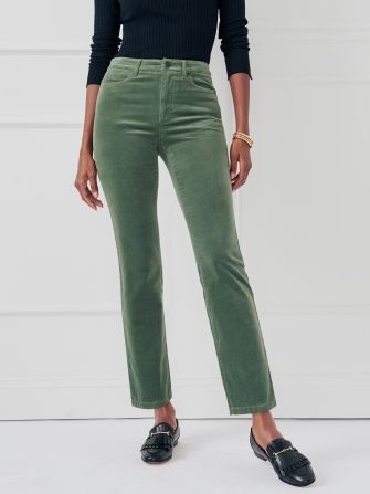 woman standing wearing green velveteen crop kick flare jeans with black loafers