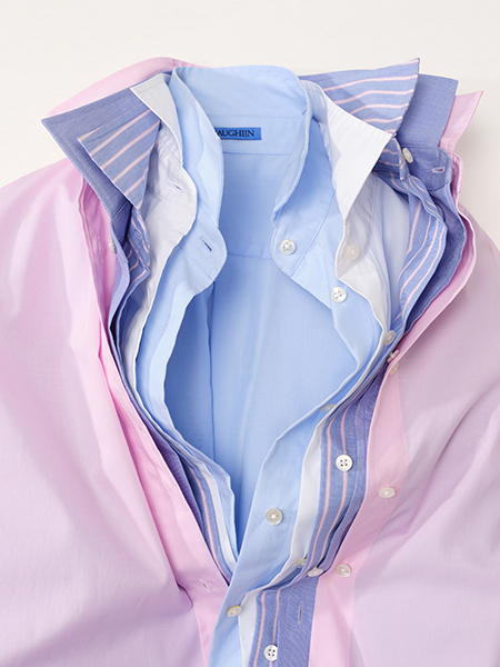 Stacked pink, blue, and striped dress shirts with open collars.