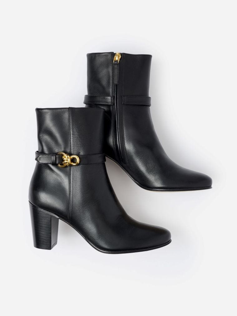 Pair of black leather ankle boots with gold buckle and zipper details.
