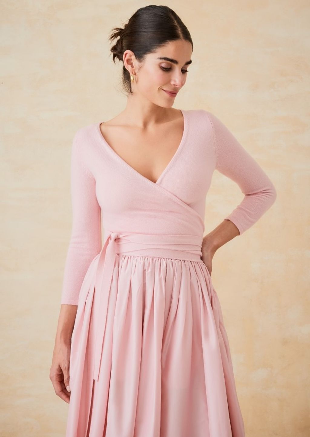 woman wearing a light pink wrap sweater