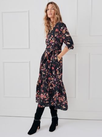 woman wearing black floral midi dress with tall boots