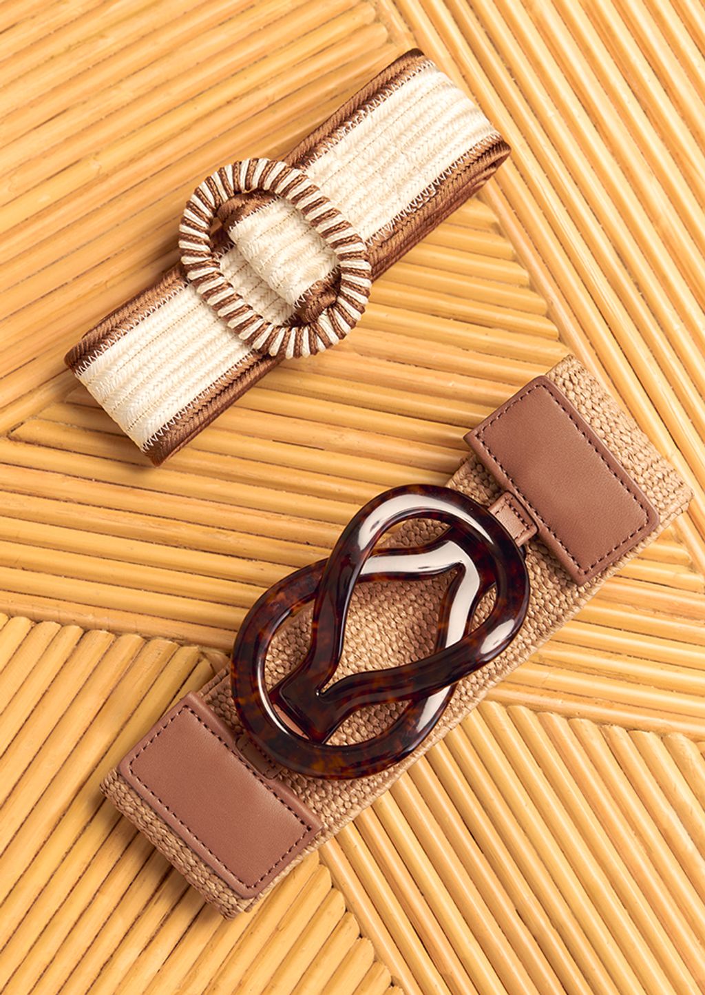 2 belts posed on bamboo table top