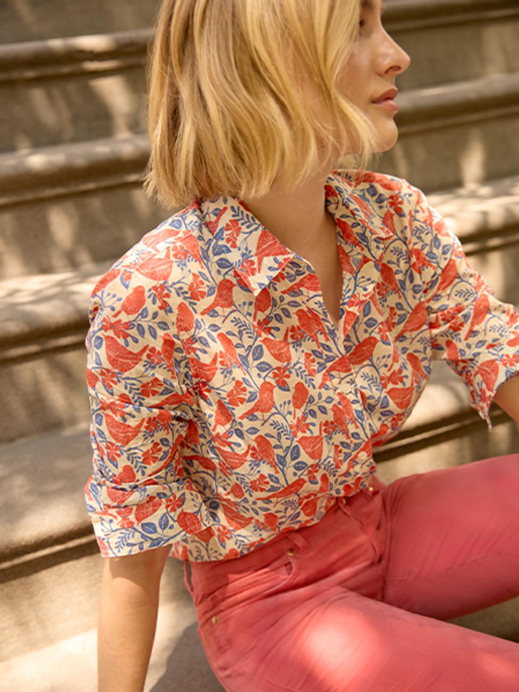 Model wearing printed button-down and velveteen pants.