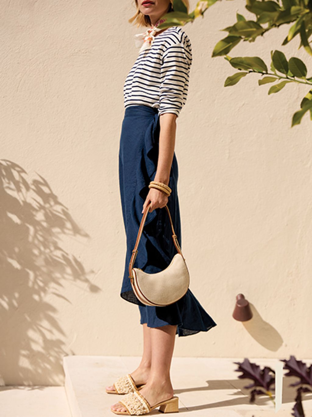 Model in striped tee, linen skirt, and beaded slides