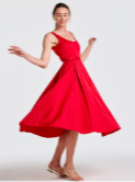 A woman in a vibrant red flowing midi dress, posed as if twirling.