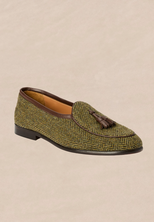 laydown of mens olive herringbone loafer on light brown studio background