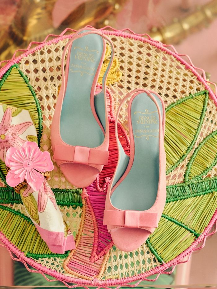 laydown of womens pink peep bow toe heels on pink and green floral pattern table