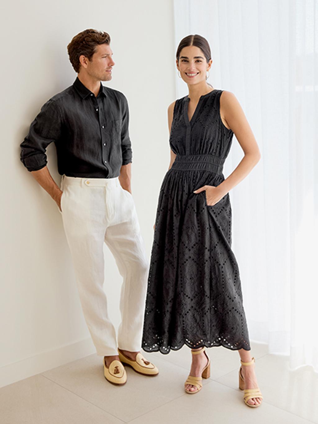 Man in black shirt and white pants with a woman in a black dress