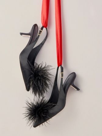 womens black slingback pumps with pom pom detail hanging from red ribbon