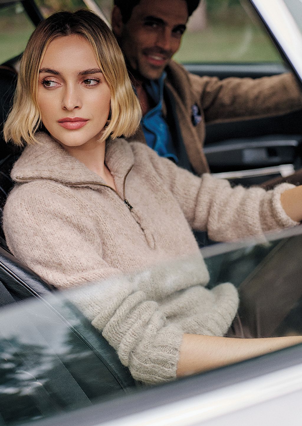 Woman in a chunky sweater sitting in a car