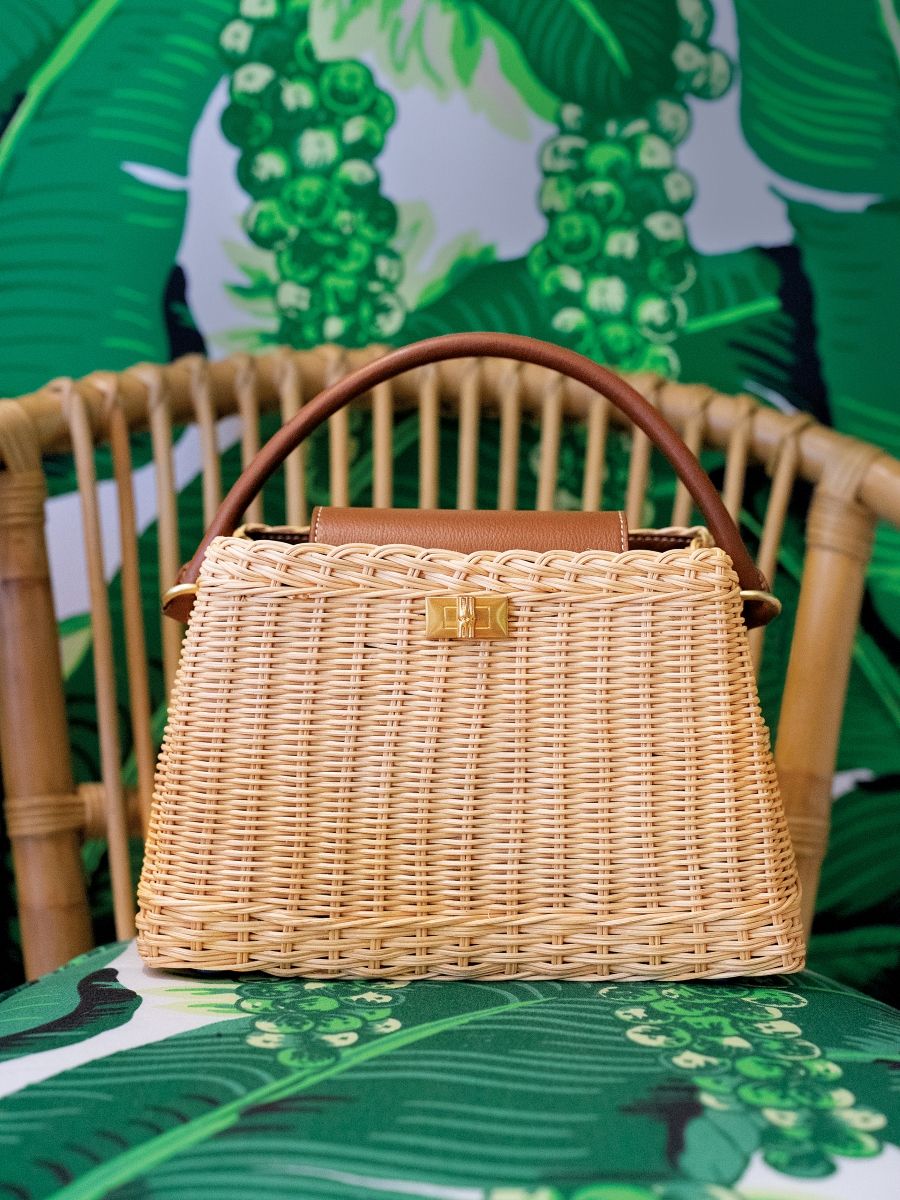 womens wicker bag on palm printed rattan chair