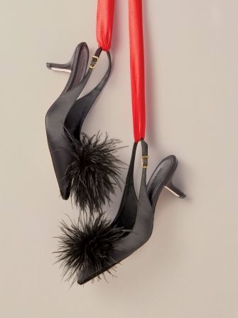 pair of womens black open toe mule heels with pom pom