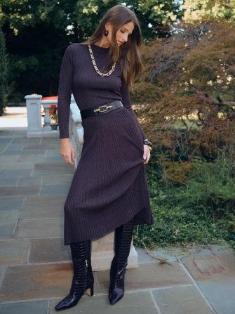 woman standing outside wearing a light brown pleated metallic knit matching skirt and knit top