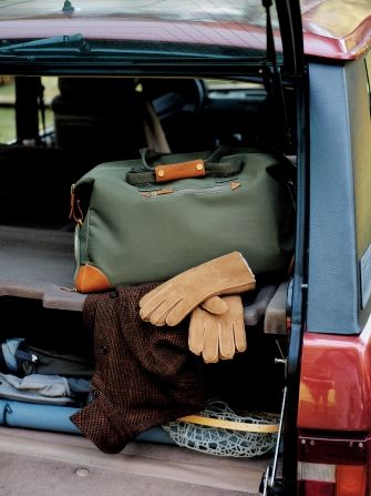 mens olive duffle bag in the trunk of a car