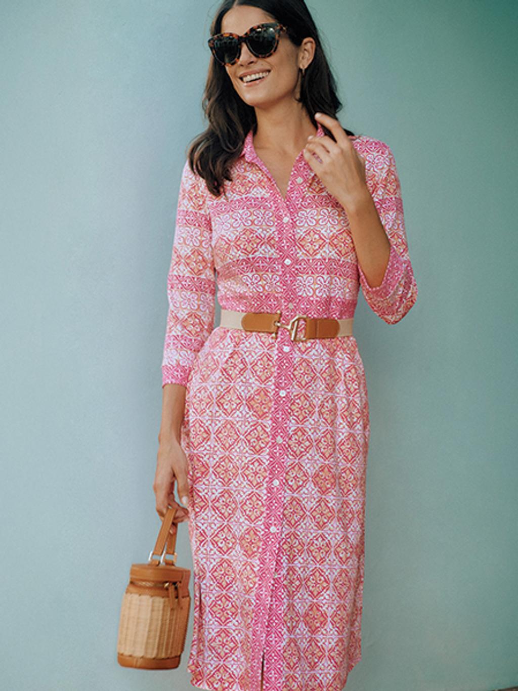 Model in pink tile-print shirtdress with wicker bag