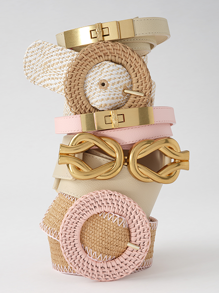 A vertical stack of diverse belts in natural tones and pink, featuring gold and woven buckles.