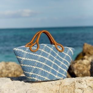 blue plaid raffia top handle tote on rock wall at beach