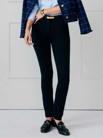 woman wearing slim black pants with black loafers and a blue button down shirt with tweed jacket