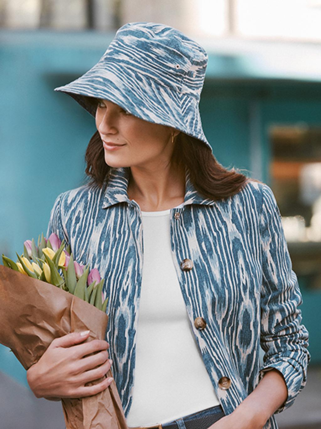 Model wearing blue and white bucket hat, coat, reversible belt, and white shirt.