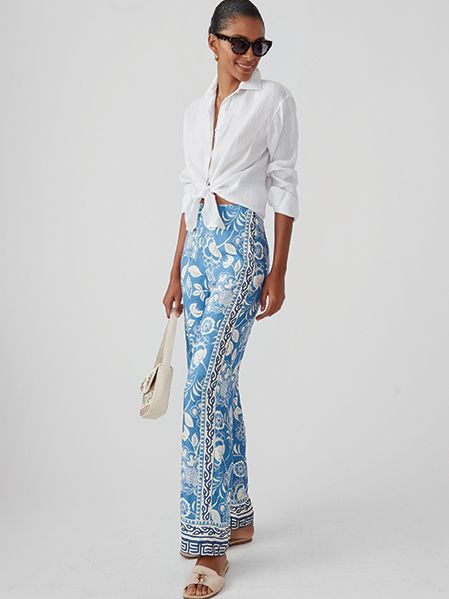 Model in knotted white shirt and blue floral pants