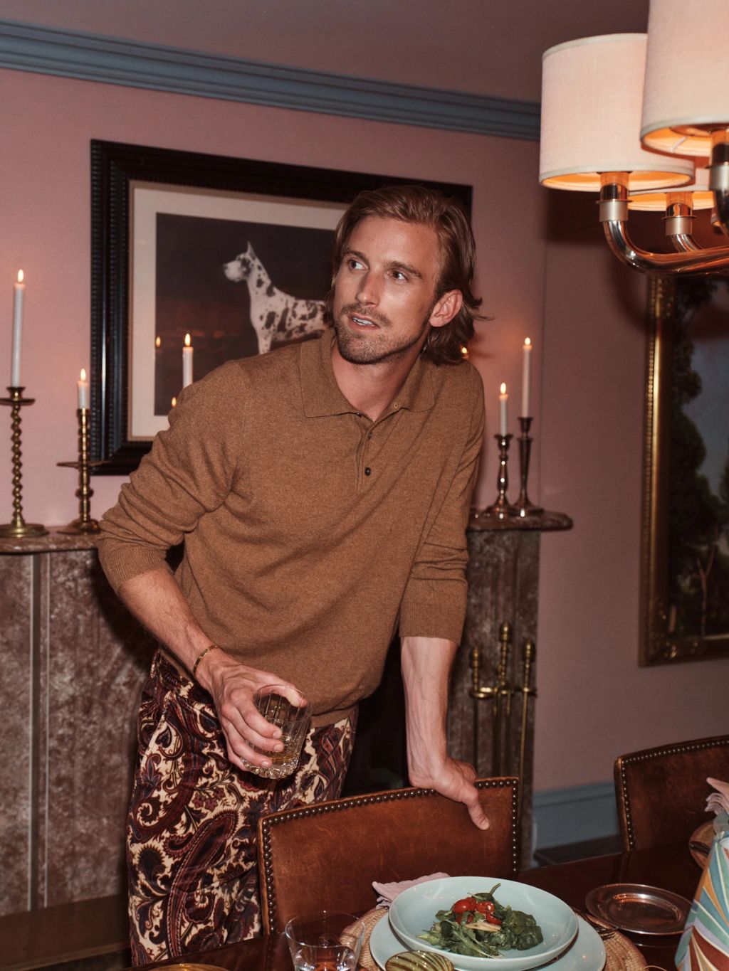 Male with cocktail in printed pants and dinner party